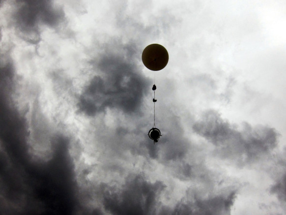 The hacker group's one-foot-diameter probe hanging from a weather balloon as it floats into the clouds above Germany. 